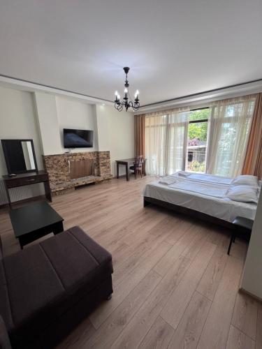 ein großes Schlafzimmer mit einem Bett und einem Sofa in der Unterkunft Guest House Madonna in Kobuleti