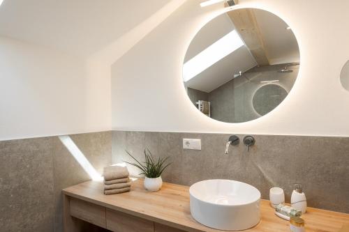 a bathroom with a white sink and a mirror at Untermairhof in Lagundo