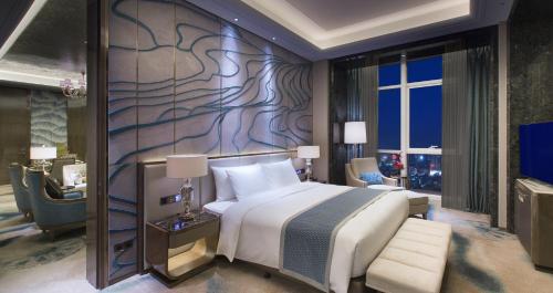 a bedroom with a large bed and a tv at Wanda Vista Nanning in Nanning
