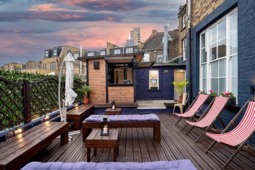 a deck with benches and chairs on a house at D8 House in London