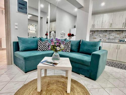 a living room with a blue couch and a table at Orianna Suites skiathos in Skiathos Town