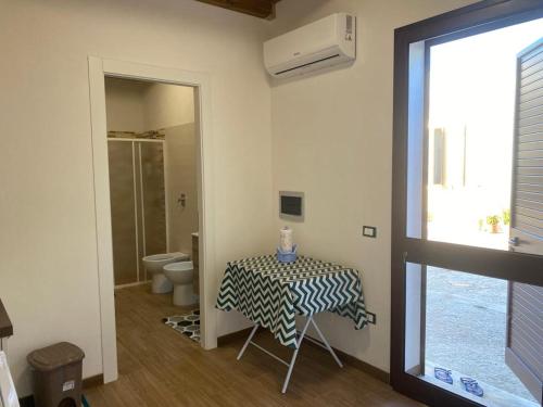 ein Bad mit einem Tisch, einem WC und einem Fenster in der Unterkunft Da Maria Casa Vacanze in Marsala