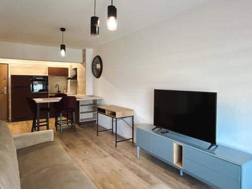BG LUXIMMO APARTMENTS في كلوي نابوكا: غرفة معيشة مع تلفزيون بشاشة مسطحة كبيرة
