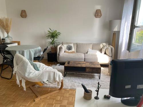 sala de estar con sofá y mesa en Havre de paix en Champigny-sur-Marne