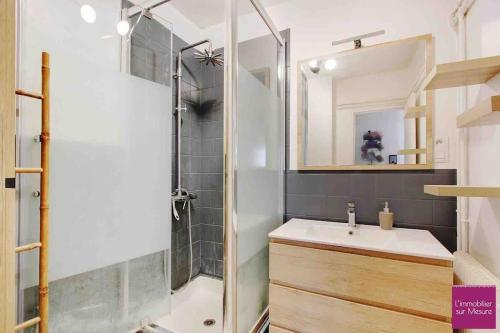 y baño con ducha, lavabo y espejo. en Havre de paix en Champigny-sur-Marne