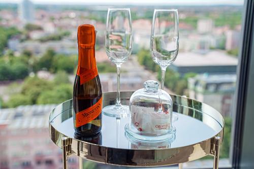 two wine glasses and a bottle on a table at Luksusowy apartament z widokiem, basenem i sauną Hanza Tower Szczecin in Szczecin