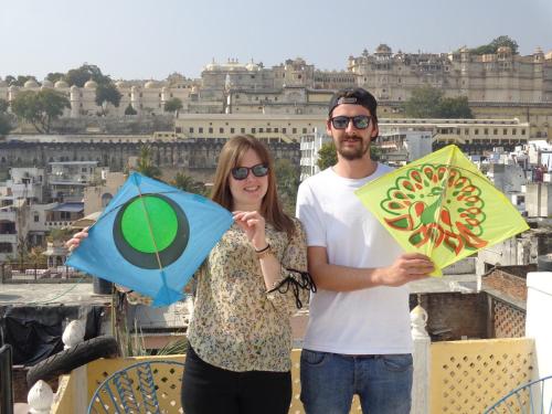 a man and woman holding kites in front of a city at Mohan Villa Guest House in Udaipur