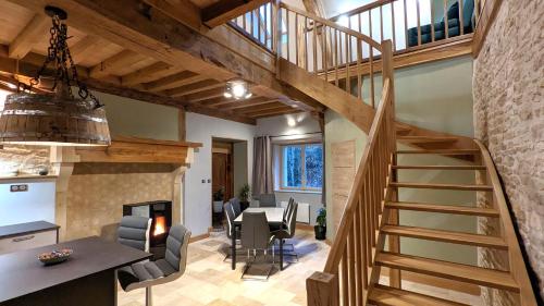 a kitchen and dining room with a spiral staircase in a house at La Ferme du Château in Beire-le-Châtel