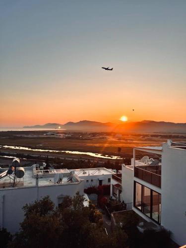 an airplane is flying over a building at sunset at SUNSET AİRPORT VİLLA in Dalaman