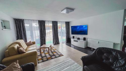 a living room with a couch and a tv at Cozy Apartman in Leisbach 