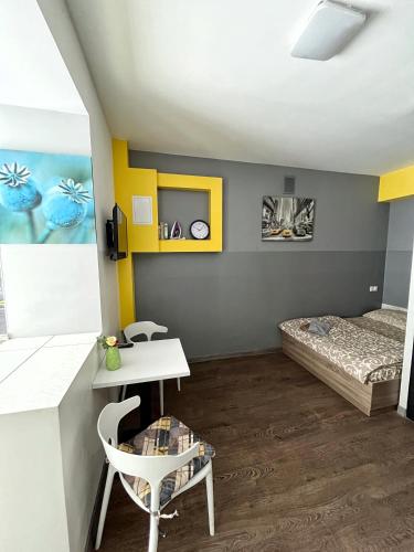 a small room with a bed and a table and chairs at — Затишні Apartments — in Ivano-Frankivsʼk