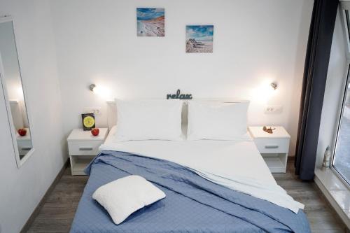 a bedroom with a large bed with blue and white sheets at Central Eden - ZF Hvar in Hvar