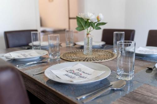 a table with plates and glasses and a vase of flowers at 1890 Apartments Bayreuth in Bayreuth