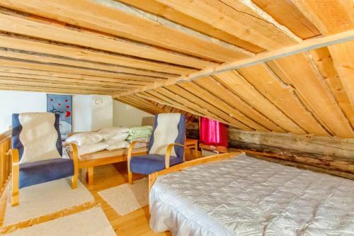 - une chambre avec un lit et deux chaises dans l'établissement Holiday Apartment Suommukelo 5, à Suomutunturi