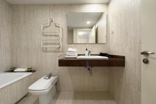 バルセロナにあるザ ロンリー チムニー アパートメントのバスルーム(洗面台、トイレ、鏡付)