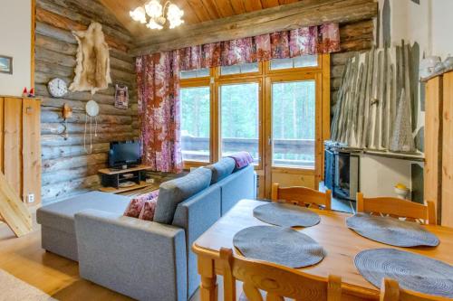 un soggiorno con un divano e un tavolo di Holiday Apartment Suommukelo 5 a Suomutunturi