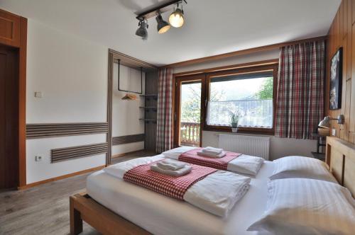 a bedroom with two beds and a window at Pension & Apartments Weissbriach in Weissbriach