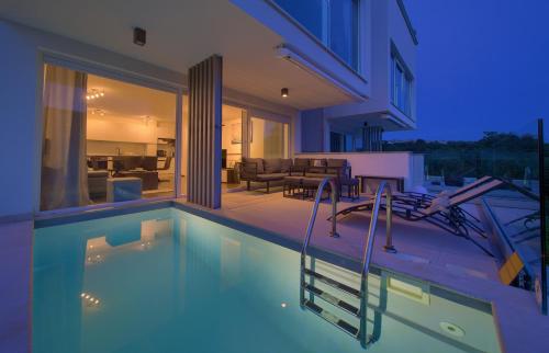 a house with a swimming pool at night at VILLA SOLIS LACUS modernes Apartment - privater beheizbarer Pool- Klimaanlage - private Parkplätze in Njivice