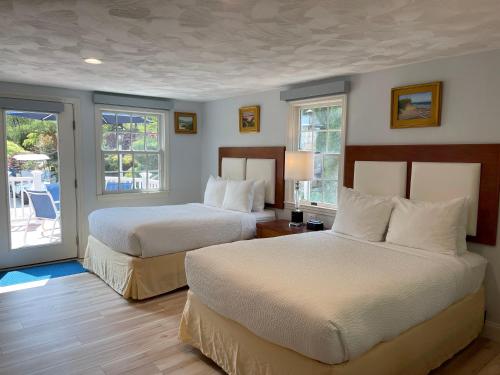 a hotel room with two beds and a balcony at Pleasant Bay Village Resort in Chatham