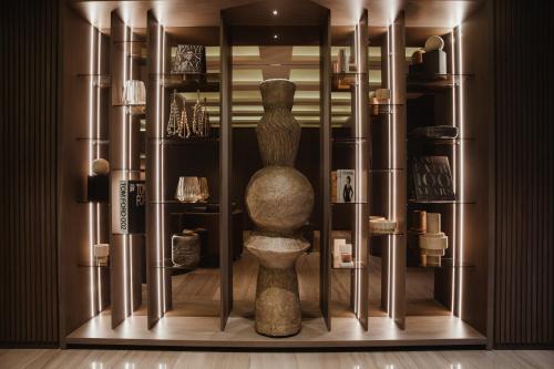 a display case with a vase in a room at Binn Hotel in Medellín