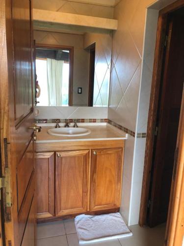 a bathroom with a sink and a mirror at casas lago in Villa Carlos Paz