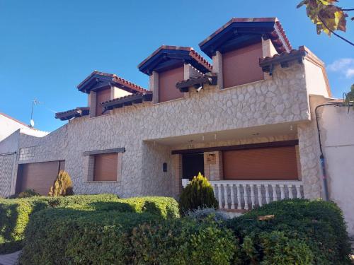 una casa grande con arbustos delante en CASA RURAL ENTREVIÑAS, en San Bernardo