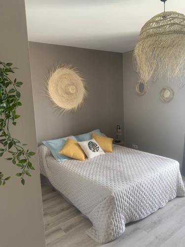 una camera da letto con un letto con cuscini gialli e blu di Chambre indépendante avec piscine a Jarnac