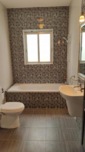 Un baño con inodoro, bañera y lavabo. en Stunning Villa with Pool, Table tennis, Table soccer and a Pool table, en Naxxar