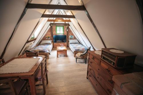 a attic room with two beds and a table at APARTMANI Etno kuća pod Okićem in Samobor