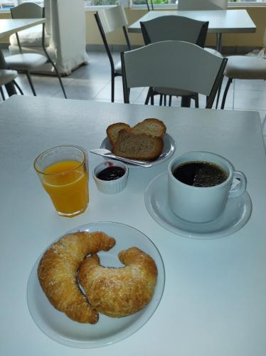un tavolo con due piatti di pretzel e una tazza di caffè di Mirador del Río Apart Hotel a Victoria