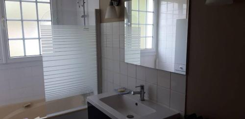 une salle de bain blanche avec un lavabo et un miroir dans l'établissement Domaine de la Panetière - Appartement Longère, à Autouillet