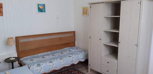 - une petite chambre avec un lit et un placard dans l'établissement Domaine de la Panetière - Appartement Longère, à Autouillet