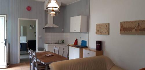 une cuisine avec une table et une salle à manger dans l'établissement Domaine de la Panetière - Appartement Longère, à Autouillet