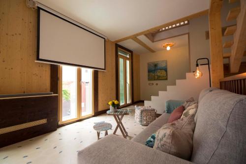 a large screen in a living room with a couch at The Wooden House VV in Las Palmas de Gran Canaria