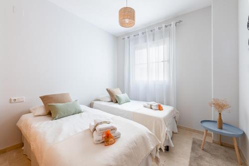 - une chambre avec 2 lits et une table bleue dans l'établissement 797 HOLIDAY RENTALS - Piso en arenal con vista al golf y mar, à Benalmádena