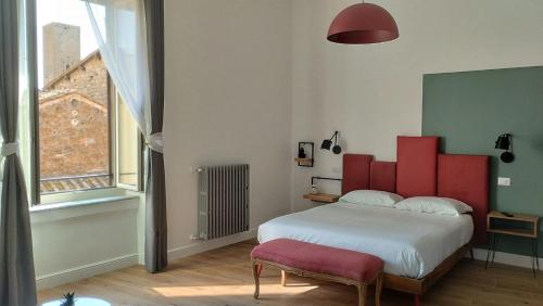 1 dormitorio con 1 cama grande y cabecero rojo en Ottantotto Viterbo, en Viterbo