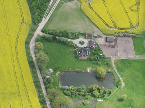 an aerial view of a house with a pond in a field at Urlaub auf dem Bauernhof in Rubitz