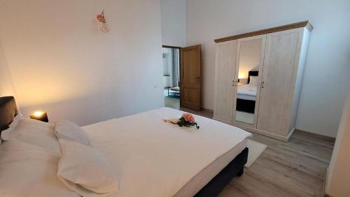 een groot wit bed in een slaapkamer met een spiegel bij Vero Residence Predeal in Predeal