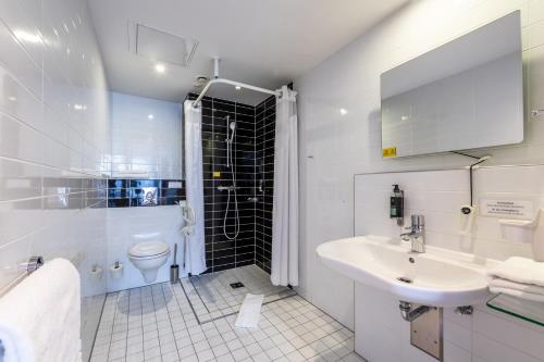 Baño blanco con lavabo y aseo en Premier Inn Hamburg City Millerntor, en Hamburgo