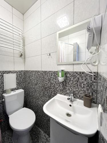 ein Badezimmer mit einem weißen WC und einem Waschbecken in der Unterkunft — Затишні Apartments — in Iwano-Frankiwsk