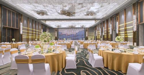 a banquet hall with tables and chairs and a stage at Wanda Vista Nanning in Nanning
