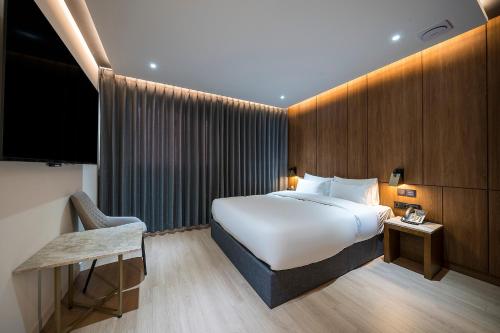 a hotel room with a bed and a television at Brown Dot Hotel Pyeonghwa plaza in Mokpo