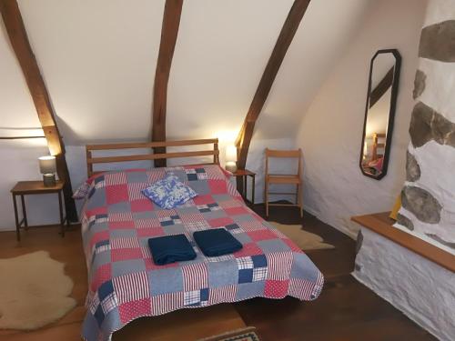 a bedroom with a bed with a red and blue blanket at La Petite Maison Pont Blanchard, in Pléaux