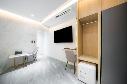 a room with a desk and a tv on a wall at Brown Dot Hotel Pyeonghwa plaza in Mokpo