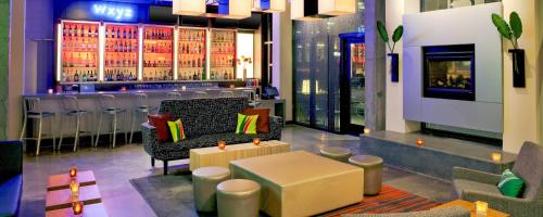a bar with a bench and a table in a room at Aloft Chesapeake in Chesapeake