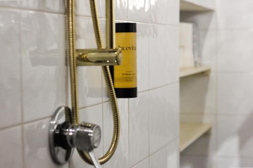 een douche met een gele en zwarte fles aan de muur bij Santo'S House BnB in Santo Stefano di Sessanio