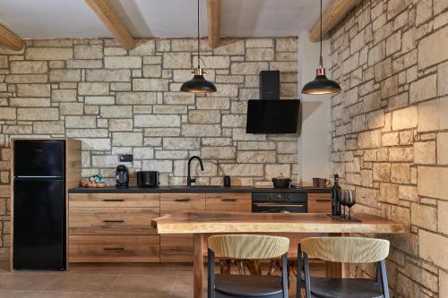 a kitchen with a wooden table and a black refrigerator at Mylostassi Villas with Balcony Plunge Pool in Pláti