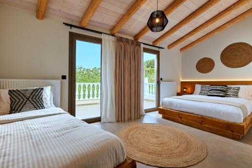 1 dormitorio con 2 camas y ventana grande en Mylostassi Villas with Heated Outdoor Pool, 