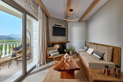 a living room with a couch and a tv at Mylostassi Villas with Balcony Plunge Pool in Pláti