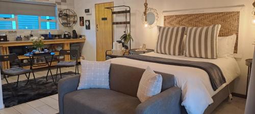- une chambre avec un grand lit et un canapé dans l'établissement Gabbys Cottage Guesthouse, à Bloemfontein